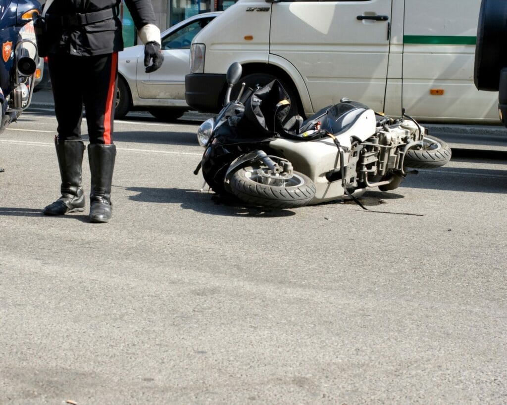 The Rose Sanders Law Firm - motorcycle accident guide; A police officer standing next to a motorcycle.